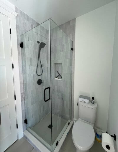 frameless glass shower enclosure with grey walls