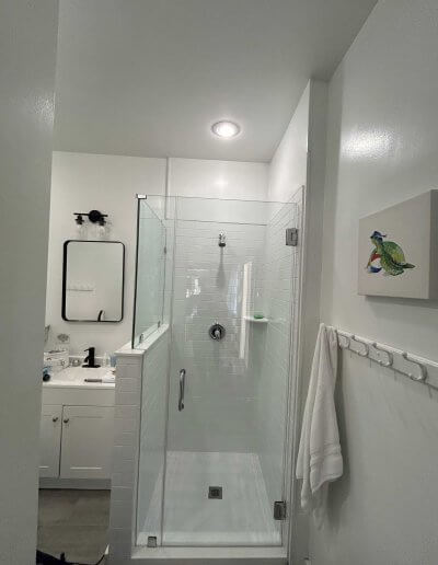 frameless glass shower enclosure with white walls