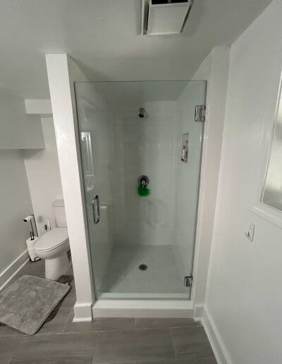 frameless glass shower door with white walls