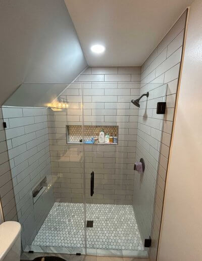 frameless shower door with white subway tile