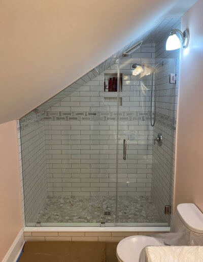 frameless shower door with slanted ceiling